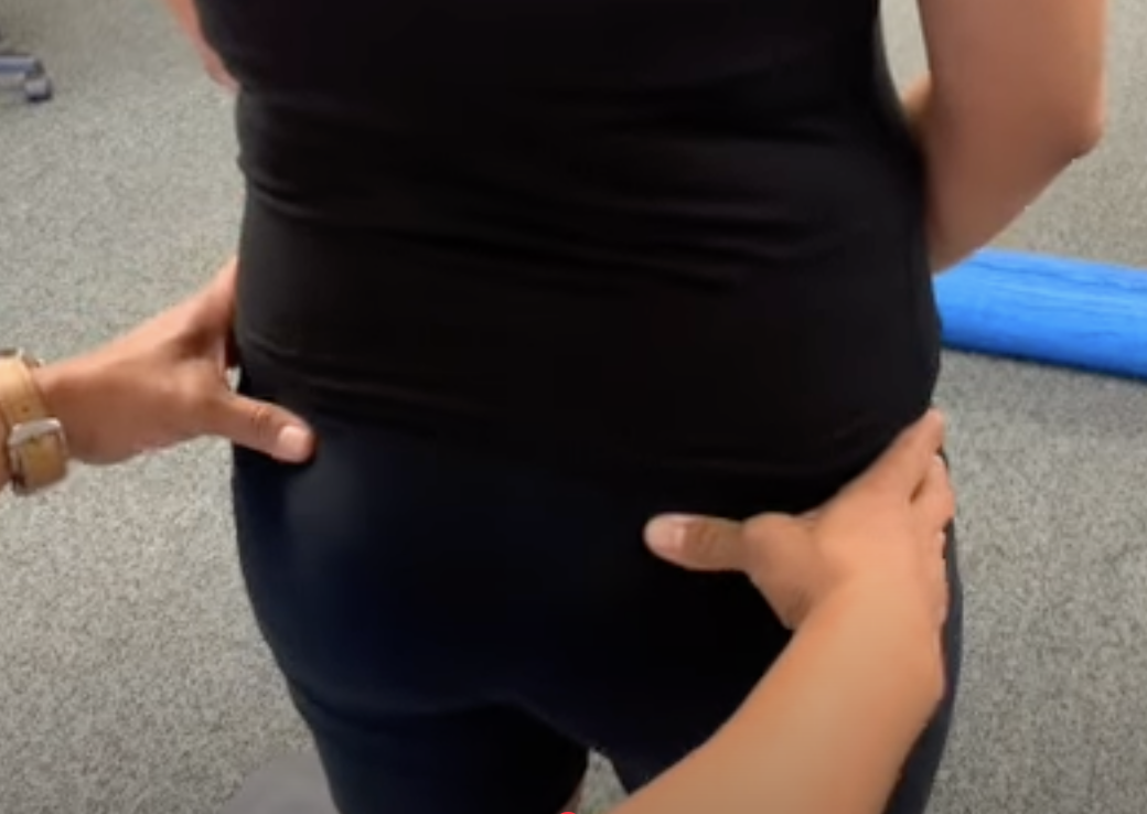 Chiropractor aligning woman's hips for posture correction